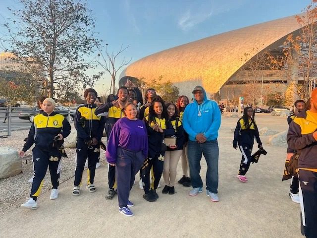 Group posing outside large modern building
